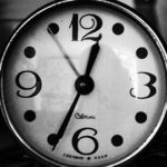 Image of a round clock with white backgrond and black numbers
