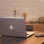 Image of a Macbook open on a kitchen table